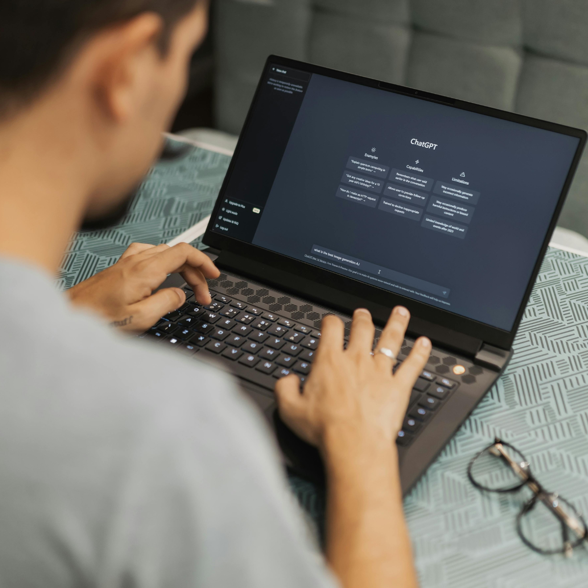 Person building an AI chatbot workflow using ChatGPT on a laptop