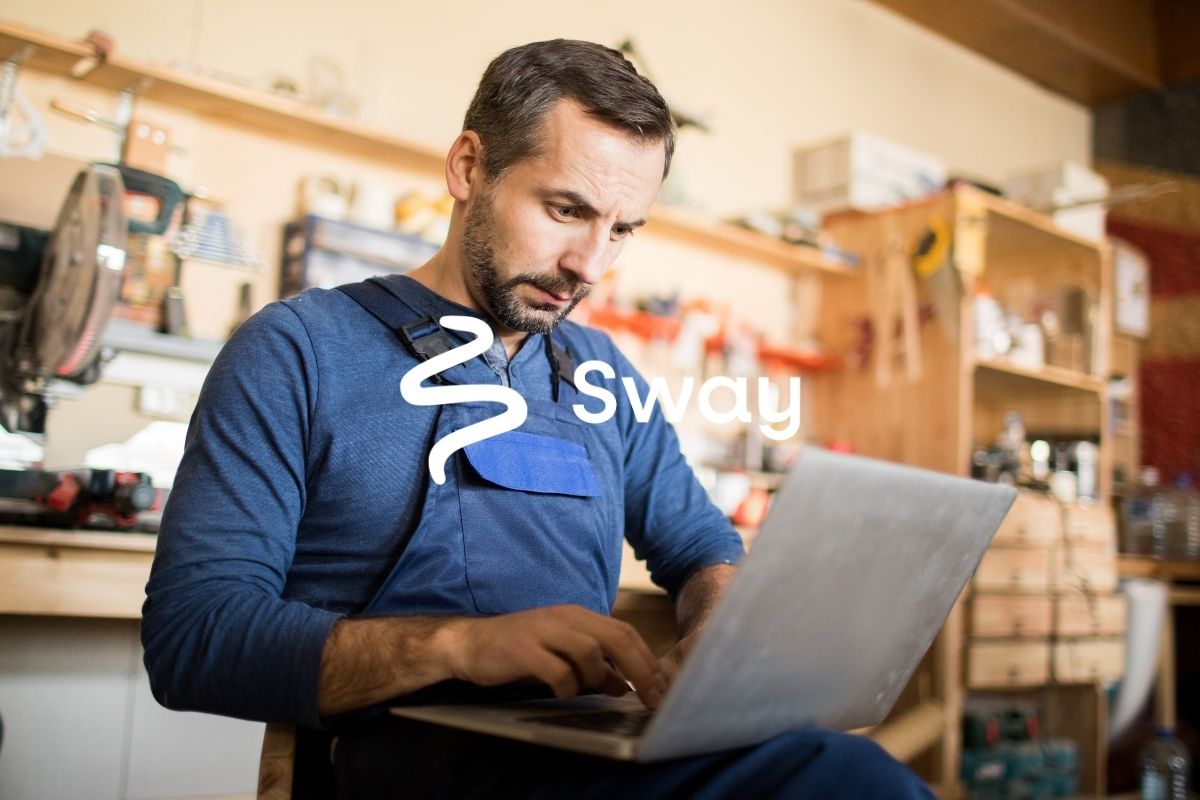 A small business owner reviewing an organic traffic dashboard on a laptop in his workshop