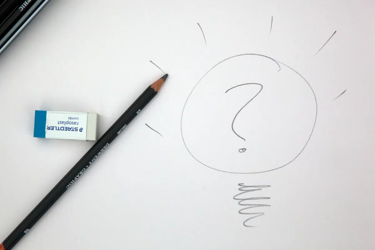 Hand-drawn pencil sketch of a lightbulb with a large question mark inside it, next to a pencil and eraser