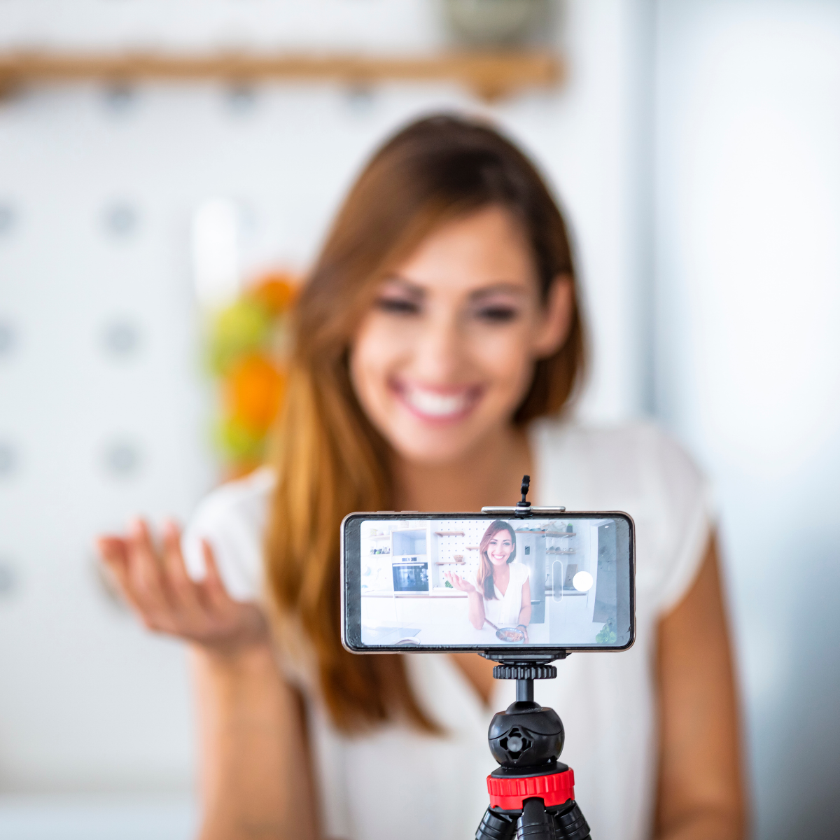 Content creator filming a video on a phone and tripod for social media